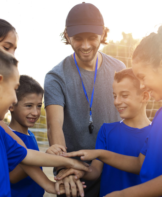 football-trainer-helping-kids-